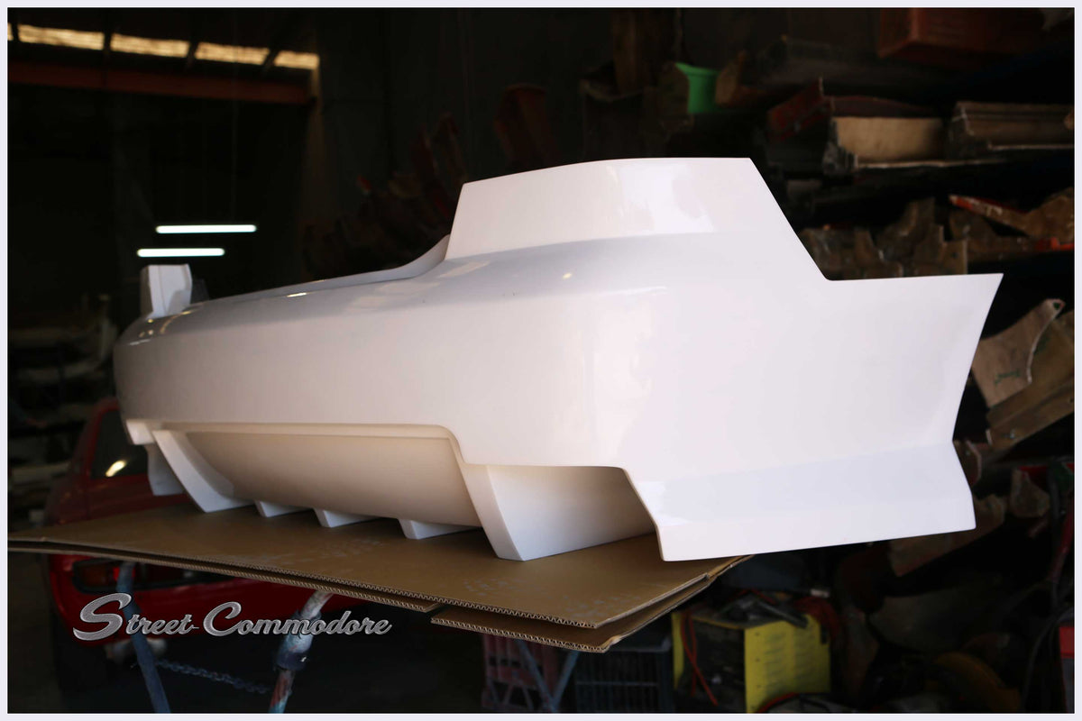 Super V8 rear bumper in raw white gel coat, right side profile showing lower strakes