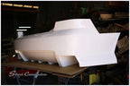 Super V8 rear bumper in raw white gel coat, right side profile showing diffuser-style strakes